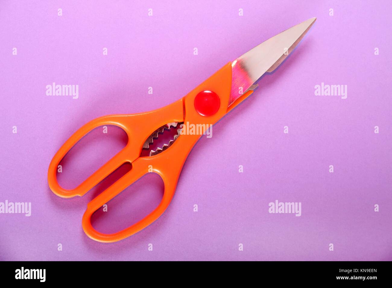 A Scissor on a purple paper background Stock Photo - Alamy
