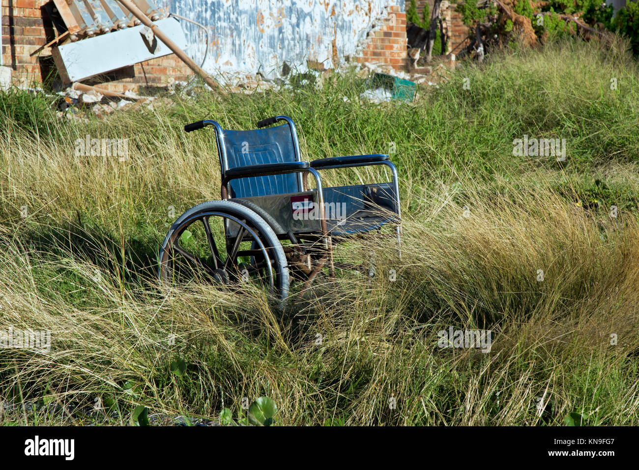 Abandoned wheelchair resting at destroyed housing complex, resulting from hurricane 'Harvey' 2017. Stock Photo
