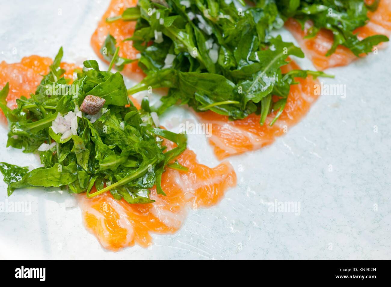 fresh salmon carpaccio sushi sashimi with arugula rocket salad and
