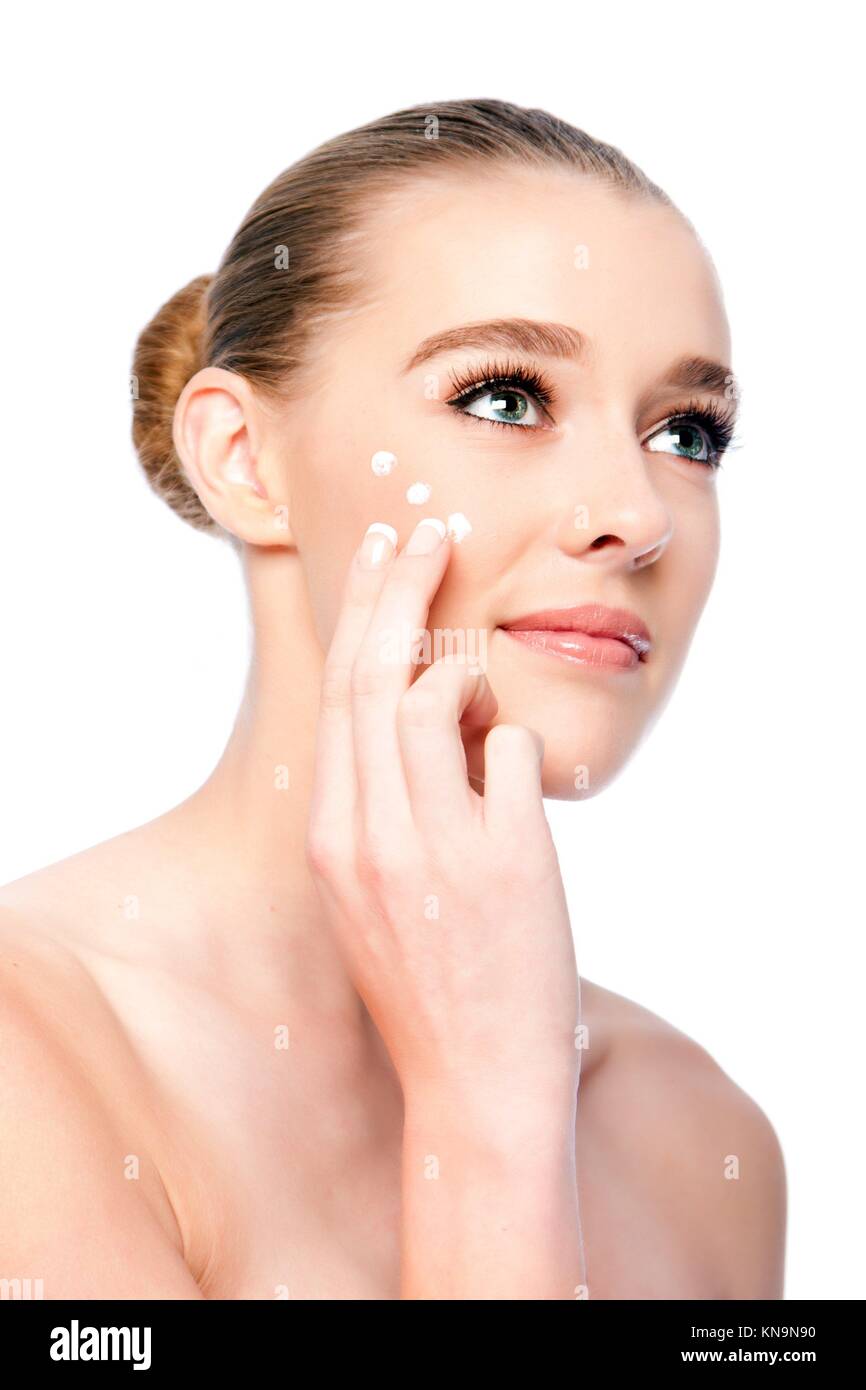Beautiful woman applying Moisturizing facial skincare treatment cream. Stock Photo