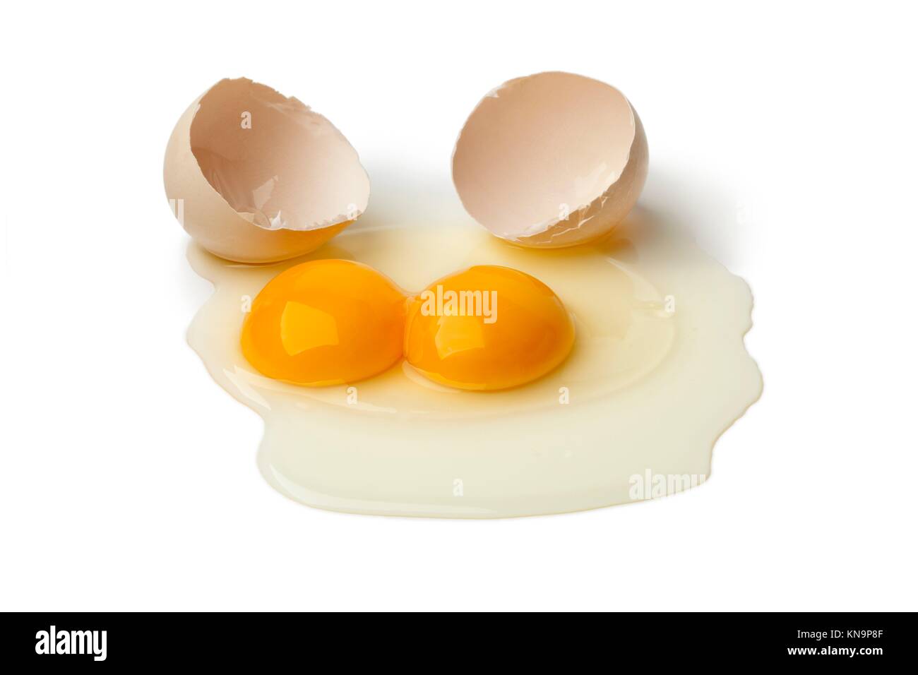 Broken raw double yolk egg on white background. Stock Photo