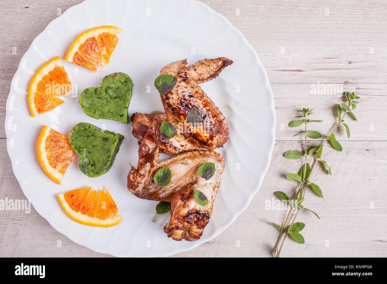 Plate of marinated chicken wings fried and garnished with spinach puree