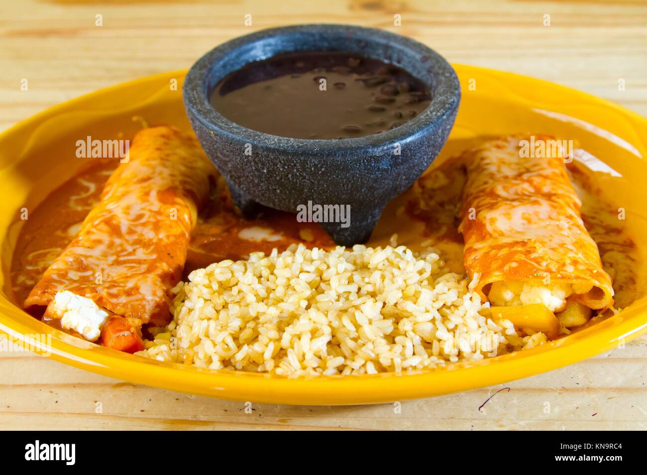 Enchiladas and rice and beans at a Mexican restaurant serving authentic cuisine. Stock Photo