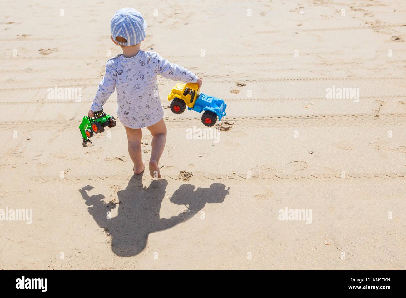Baby boy walking with toys at the beach. El Rompido, Cartaya, Huelva