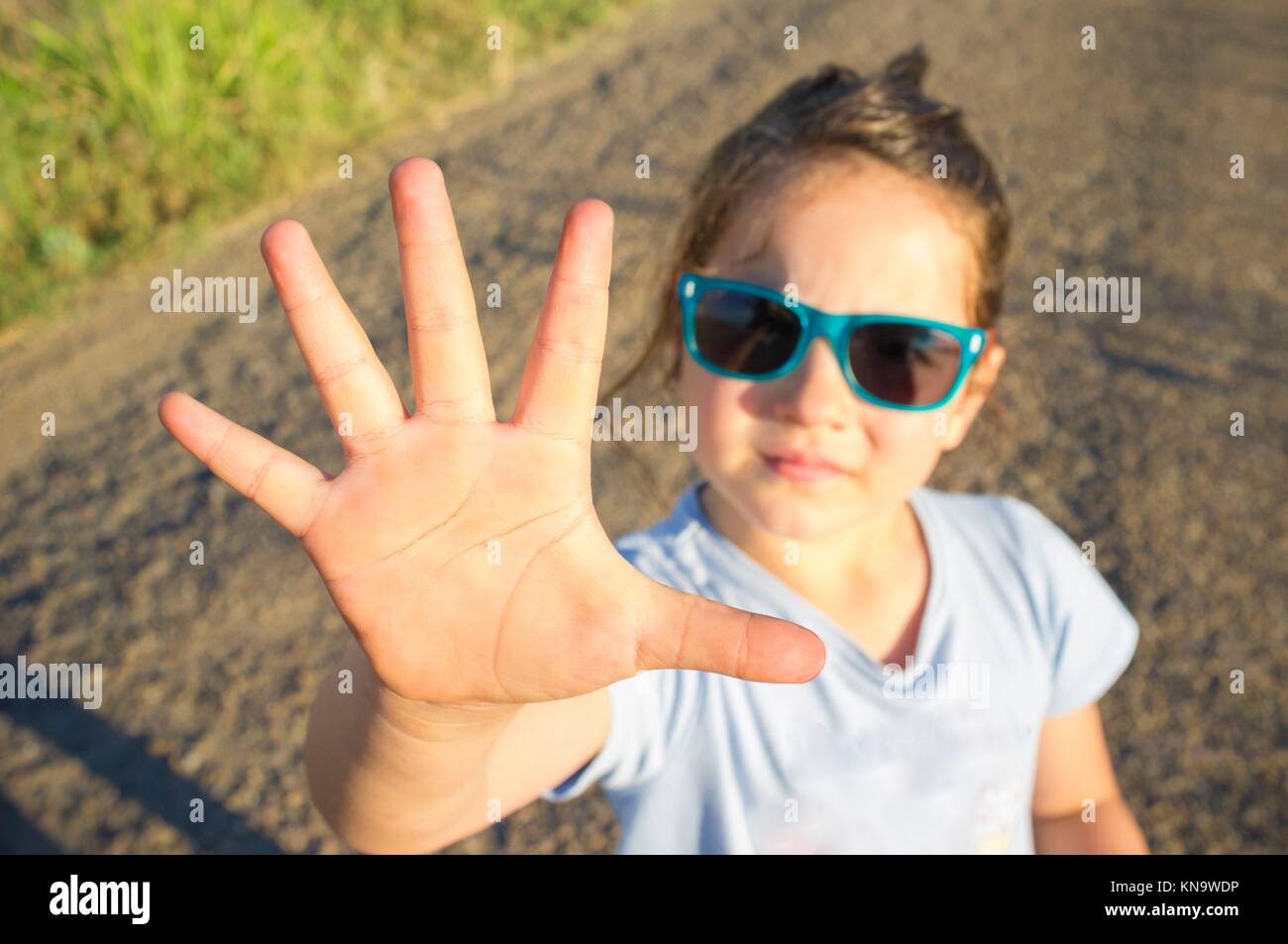 5 years old little girl shows five fingers. Closeup. Stock Photo