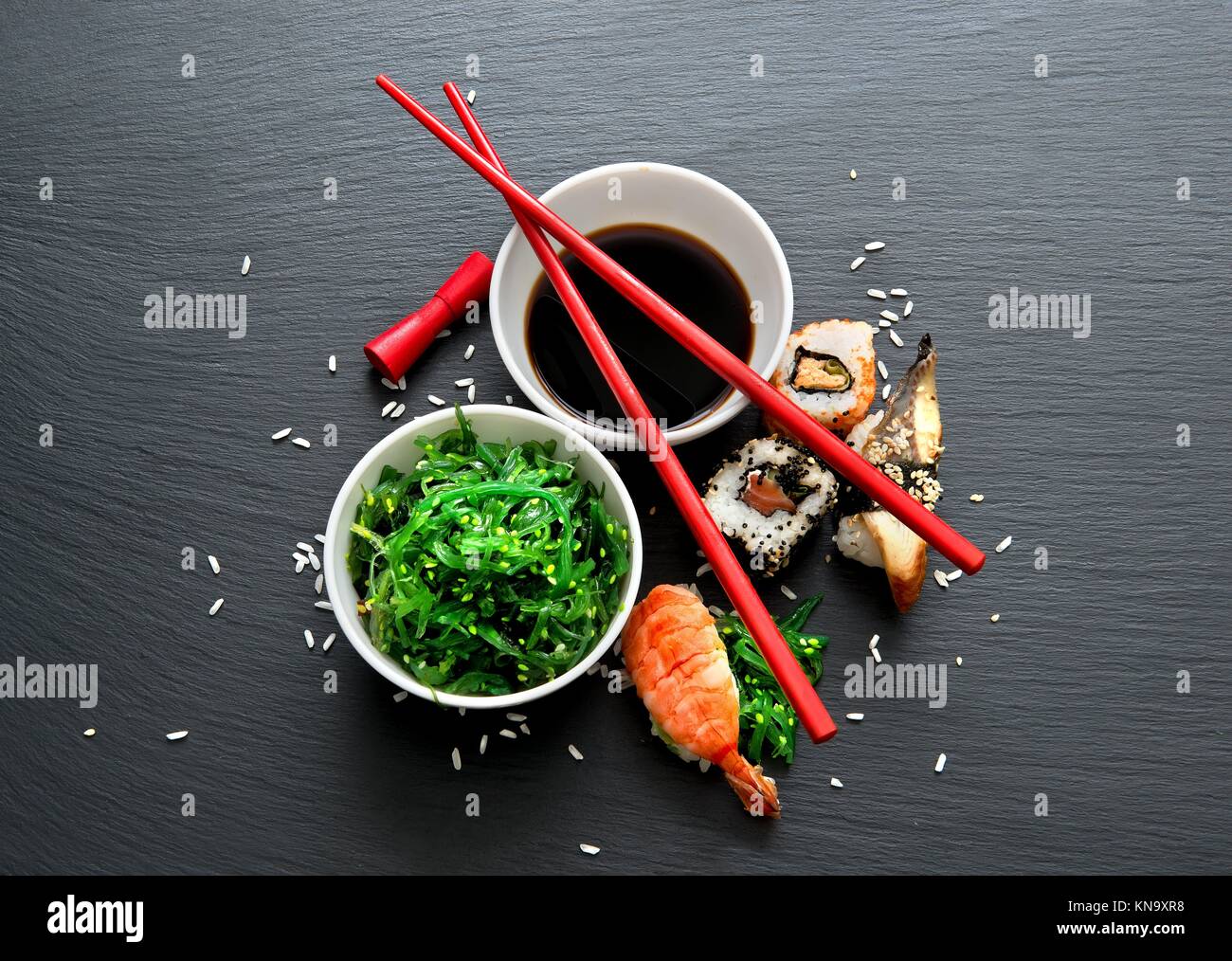 Seaweed salad and sushi on a slate table. Stock Photo