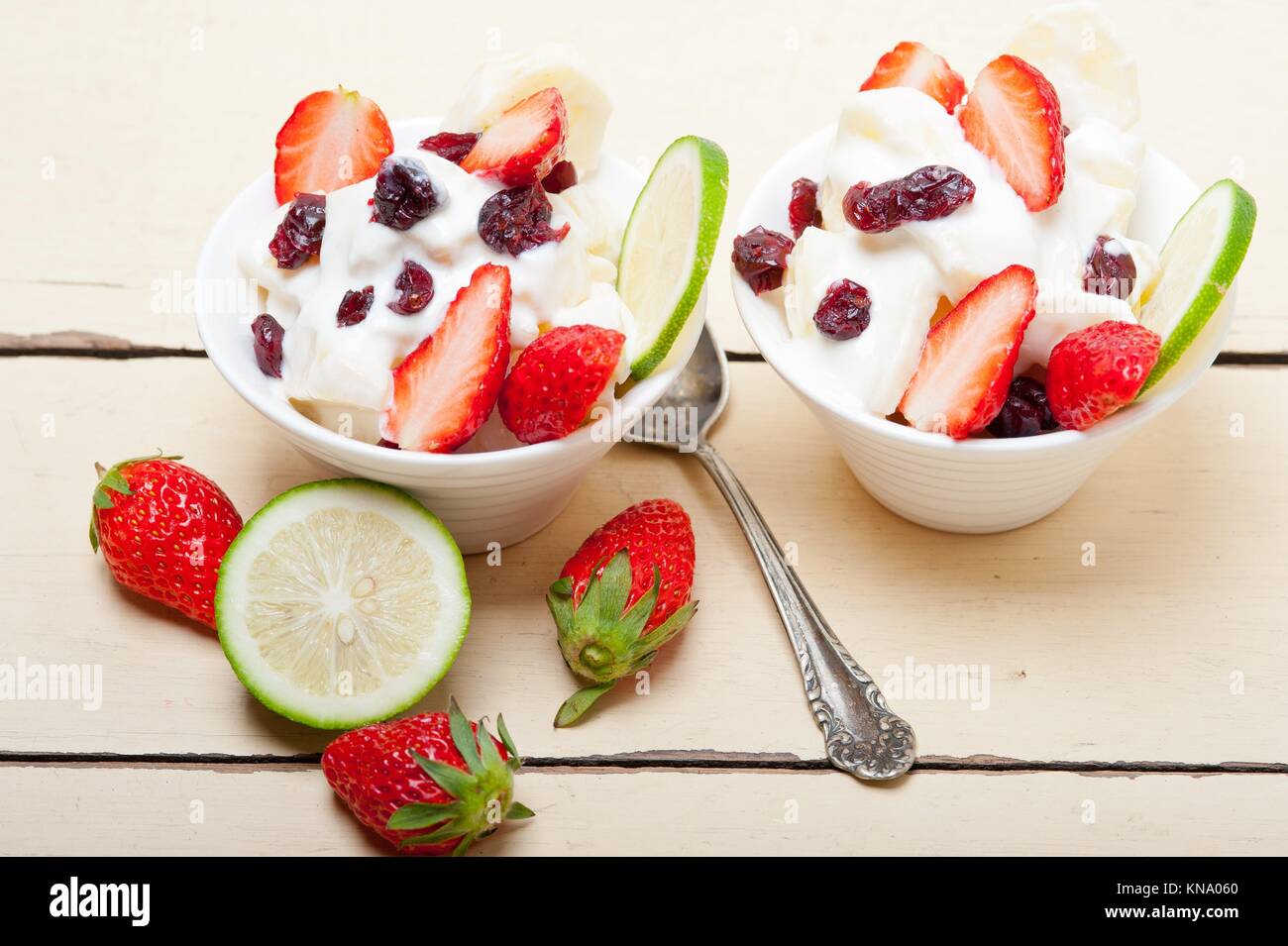 fruit and yogurt salad healthy breakfast over white wood table Stock