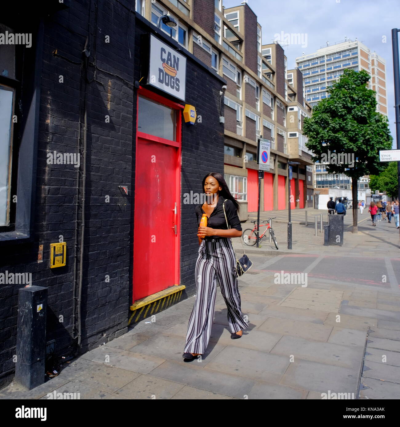 Attractive stylish Afro-Caribbean woman walking down street in London, England, UK Stock Photo