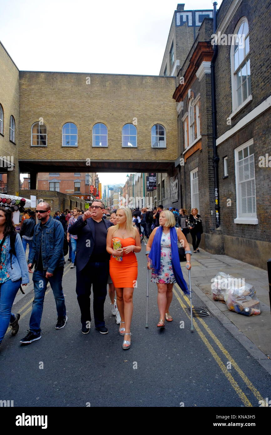 Attractive young blonde woman wearing tiara with family on Brick Lane in Shoreditch, London, England, UK Stock Photo