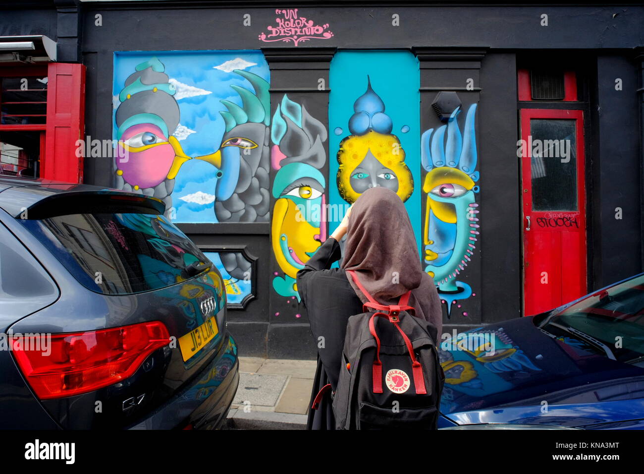 Muslim girl in hijab photographing graffiti in Shoreditch, London, England, UK Stock Photo