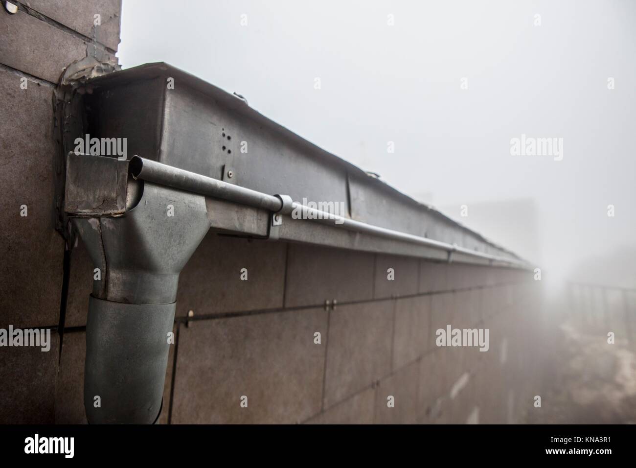 Gutter drainage system on the roof with dripping fog. Closeup. Stock Photo