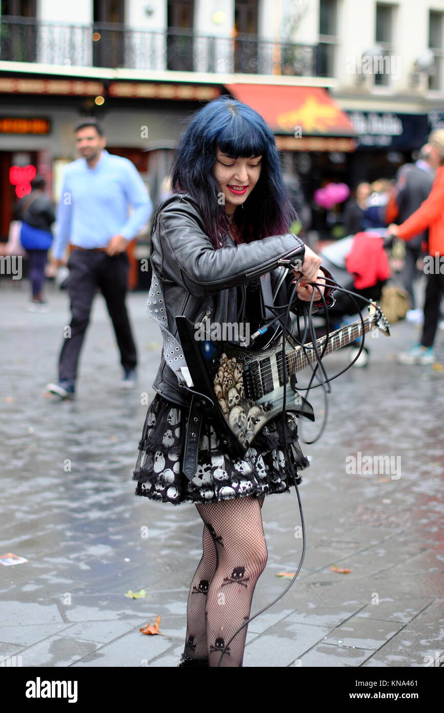 Women busker with electric guitar in Leicester Square, London, England