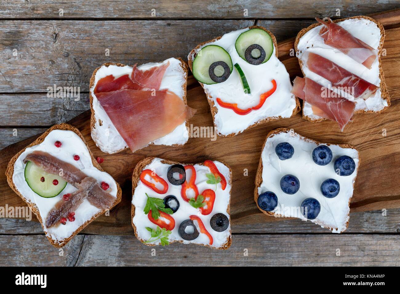Various appetizers canape style on toasted bread with cheese, cucumbers