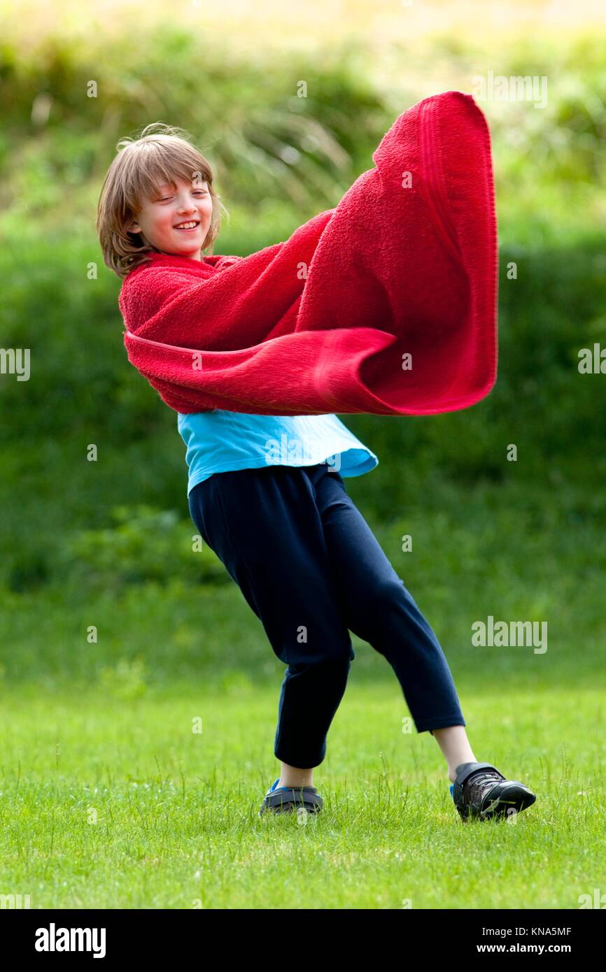 Boy Running Around in Red Towel as Superhero Cloak. Stock Photo