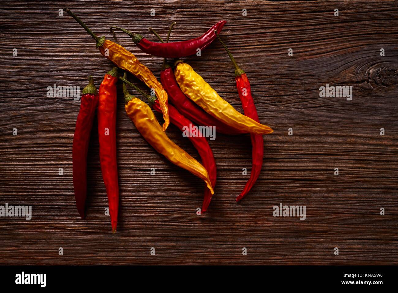 dried hot chili peppers on aged wood background Stock Photo - Alamy
