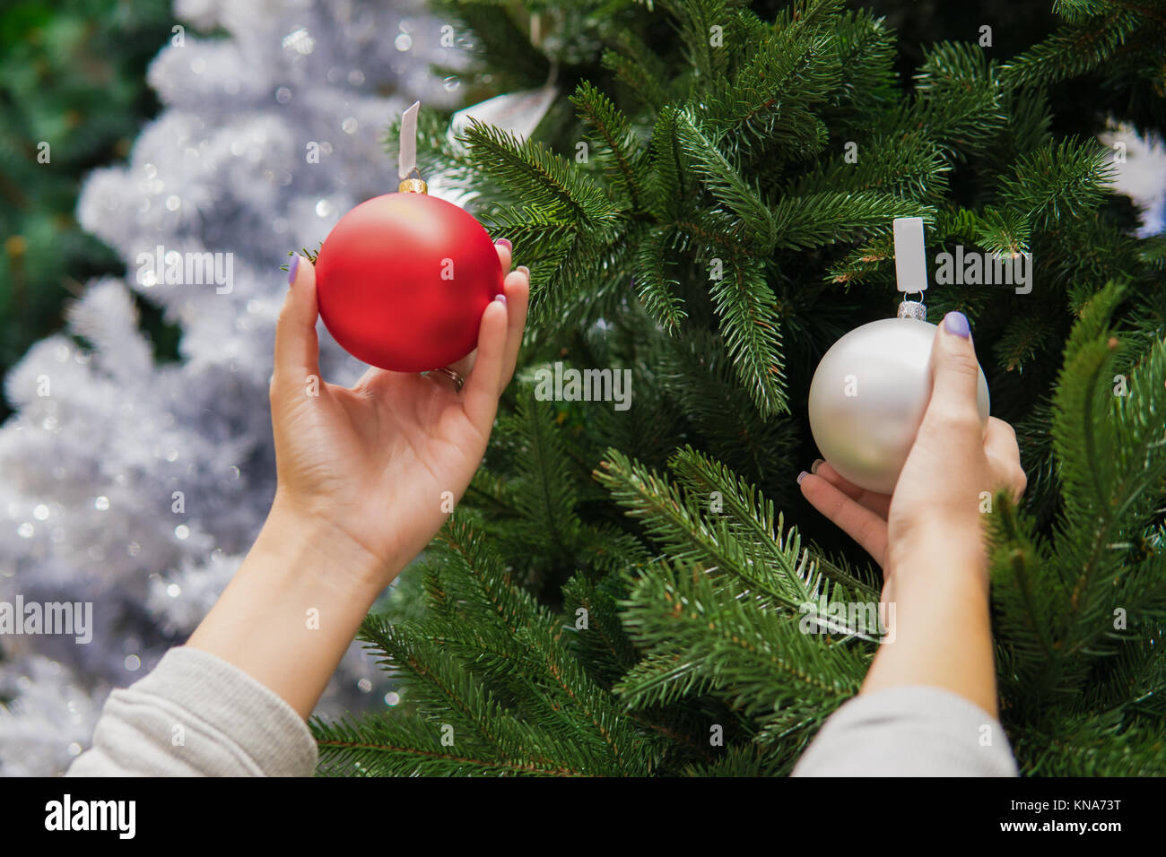 Cheerful happy customer girl choosing Christmas tree decoration balls Stock Photo