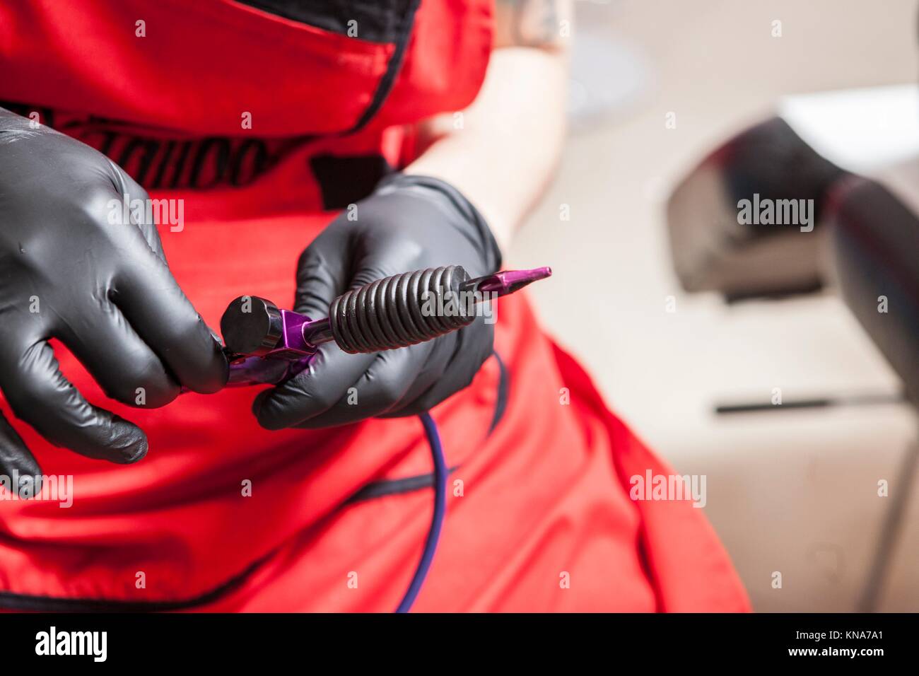 Tattoo artist adjusts the gun ink machine. Closeup Stock Photo Alamy