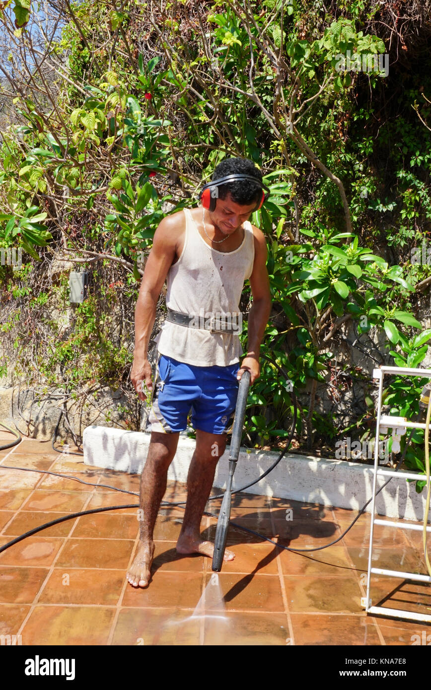 Hired help at Mexican home, Acapulco, Mexico. Pressure washing tiles Stock Photo