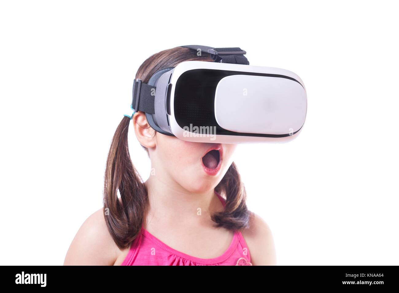 Little girl with virtual reality glasses. Isolated on white background. She is amazed. Stock Photo