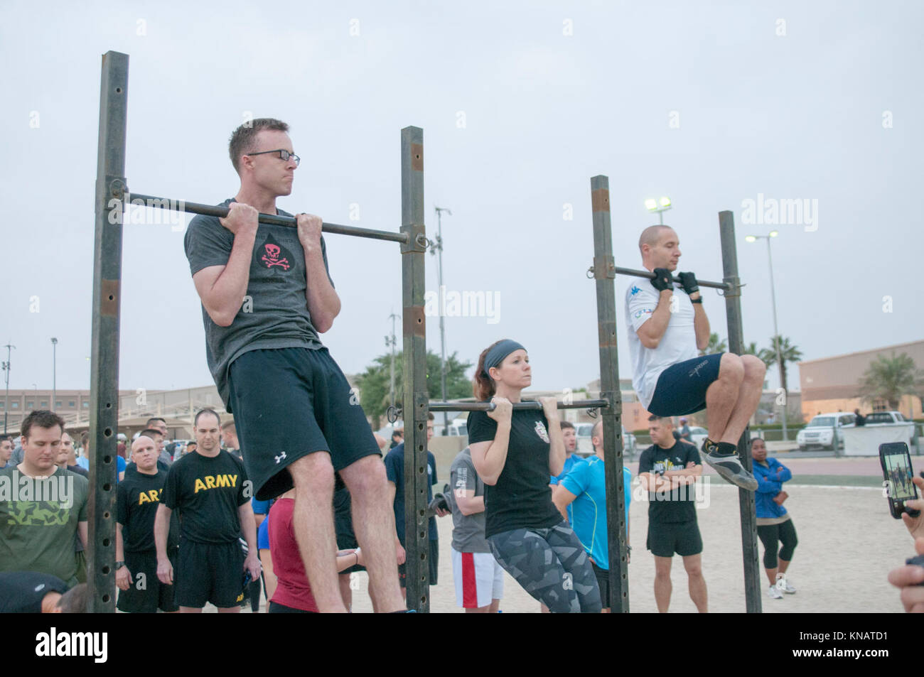 U.S. Servicemembers hold themselves above the bar during the flexedarm