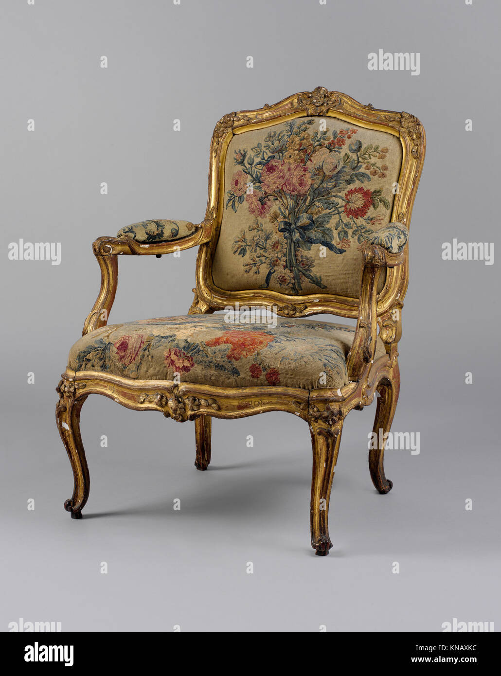 Armchair (fauteuil) MET DP130343 189343 Factory: Tapestry woven at Beauvais, Armchair (fauteuil), first half 18th century, Carved and gilded beechwood; Beauvais tapestry upholstery, Overall: 36 1/4 ? 27 ? 21 3/4 in. (92.1 ? 68.6 ? 55.2 cm). The Metropolitan Museum of Art, New York. Gift of J. Pierpont Morgan, 1906 (07.225.58) Stock Photo