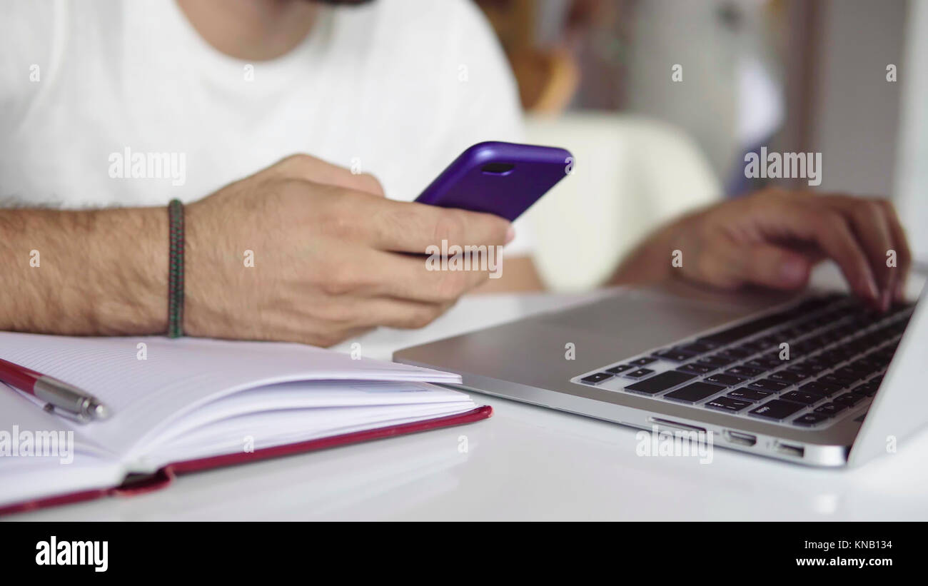Business man working at laptop and using mobile phone Stock Photo - Alamy