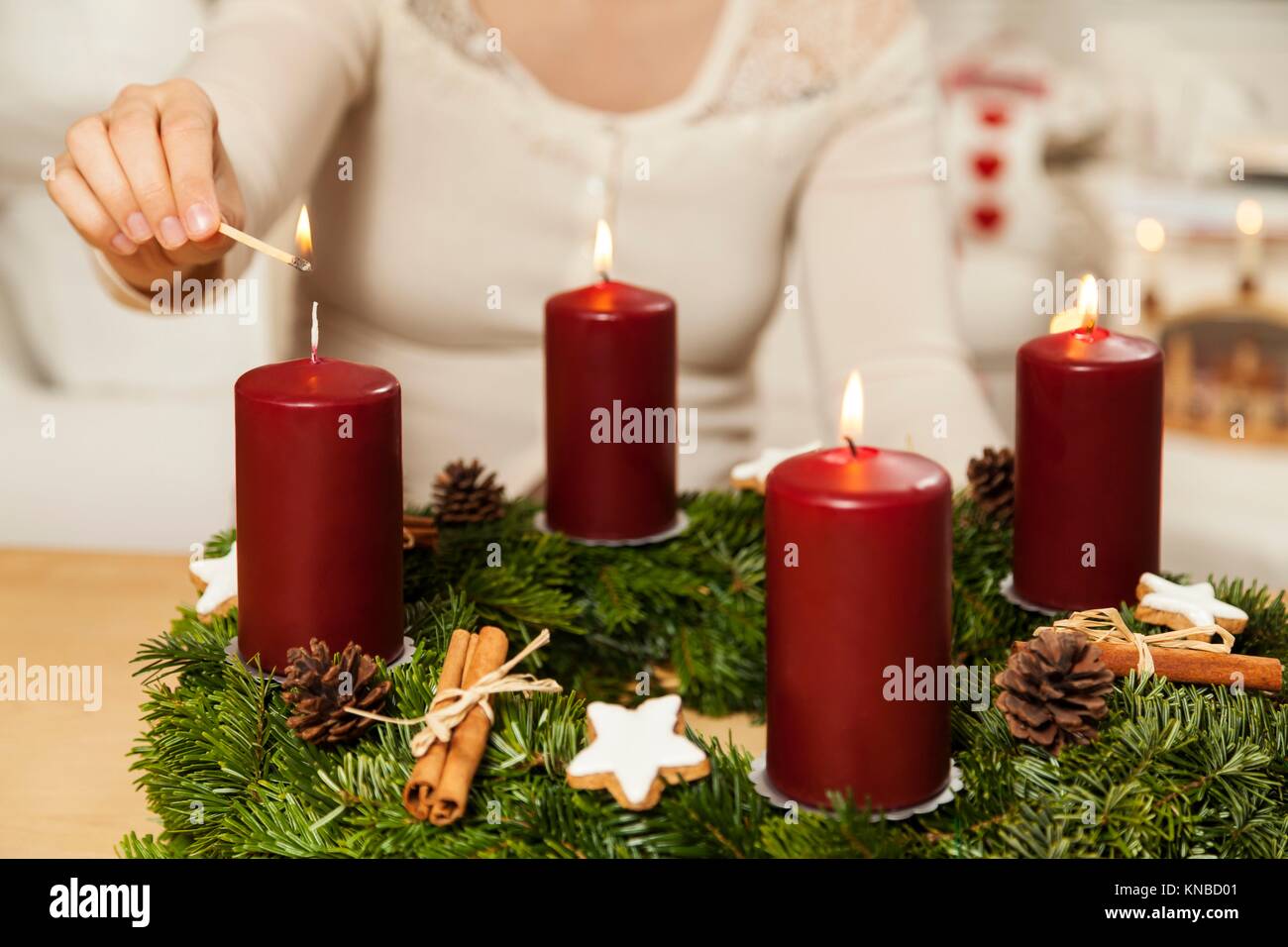 Woman lights fourth candle from Advent wreath Stock Photo Alamy