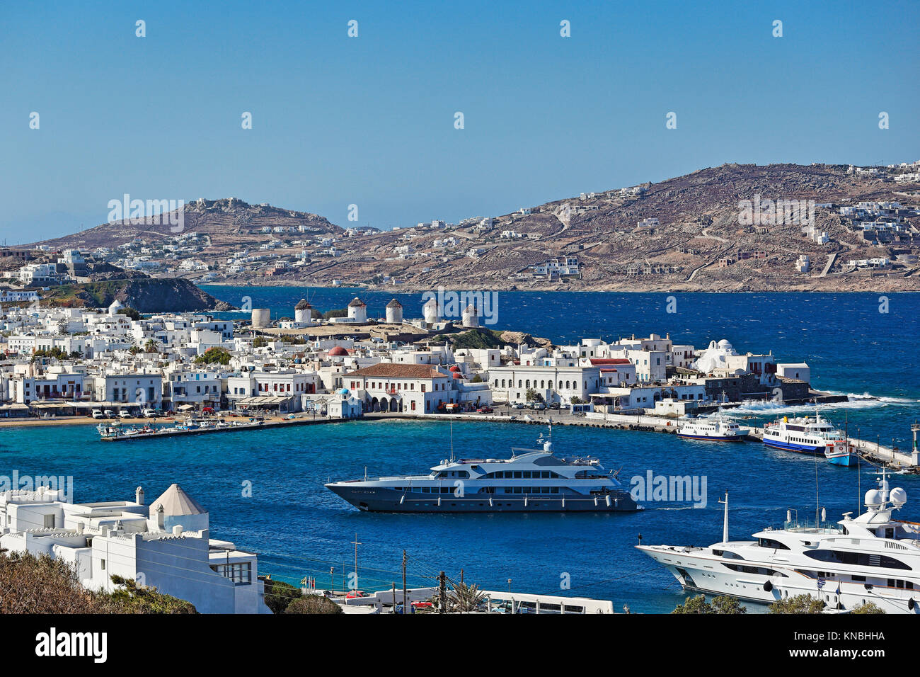 The famous windmills and the port of Mykonos, Greece Stock Photo