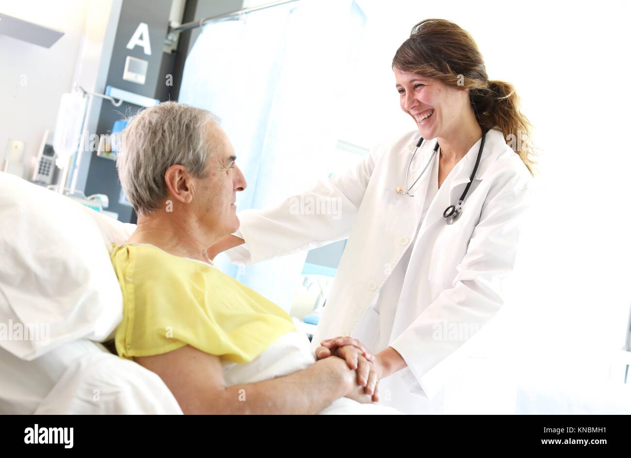 Patient in hospital room attended by a doctor, Hospital Stock Photo