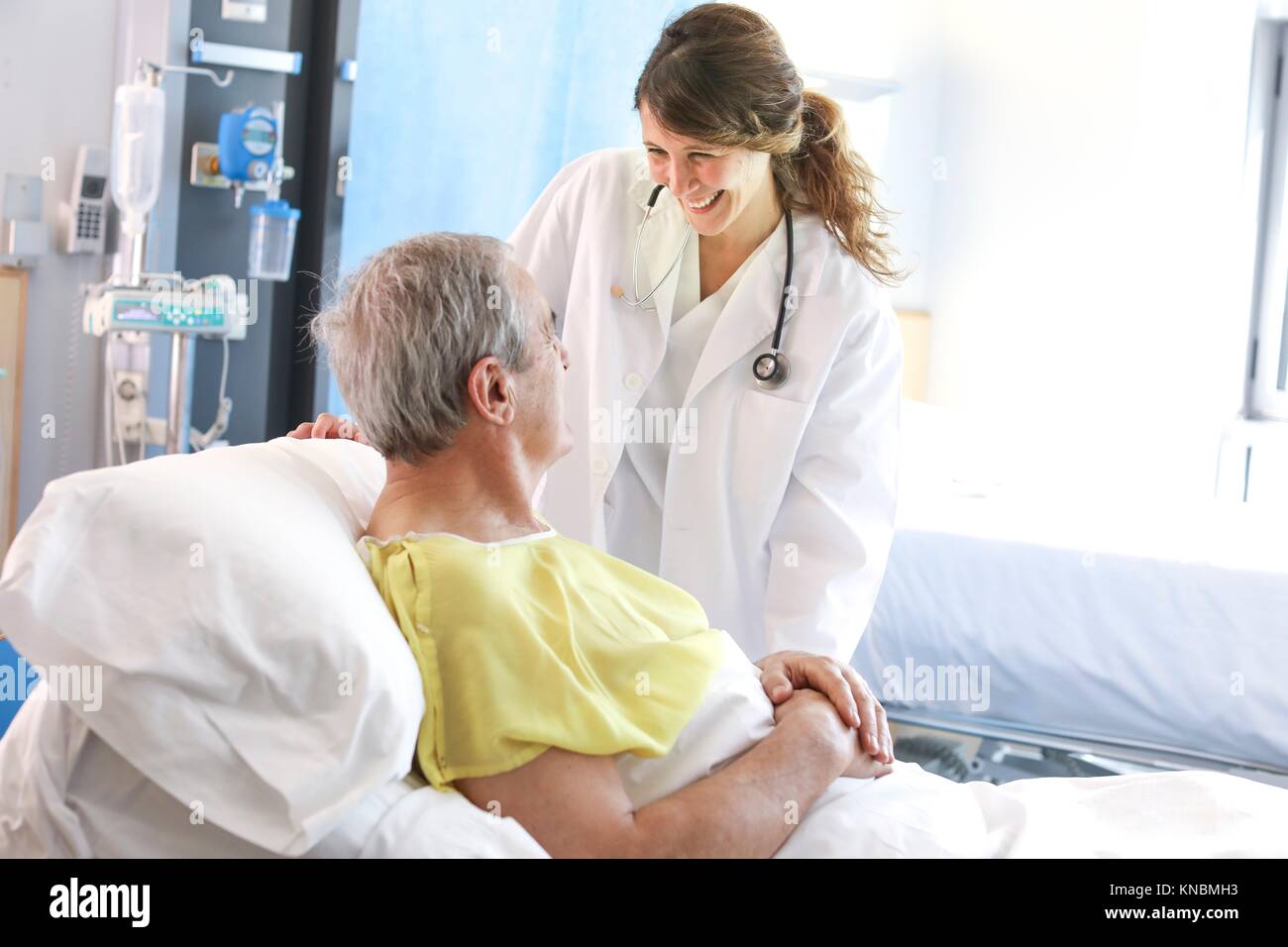 Patient in hospital room attended by a doctor, Hospital Stock Photo