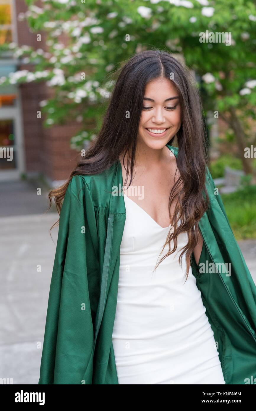 Beautiful college senior girl poses for graduation photos during the Spring on a university campus during the Spring in Oregon. Stock Photo