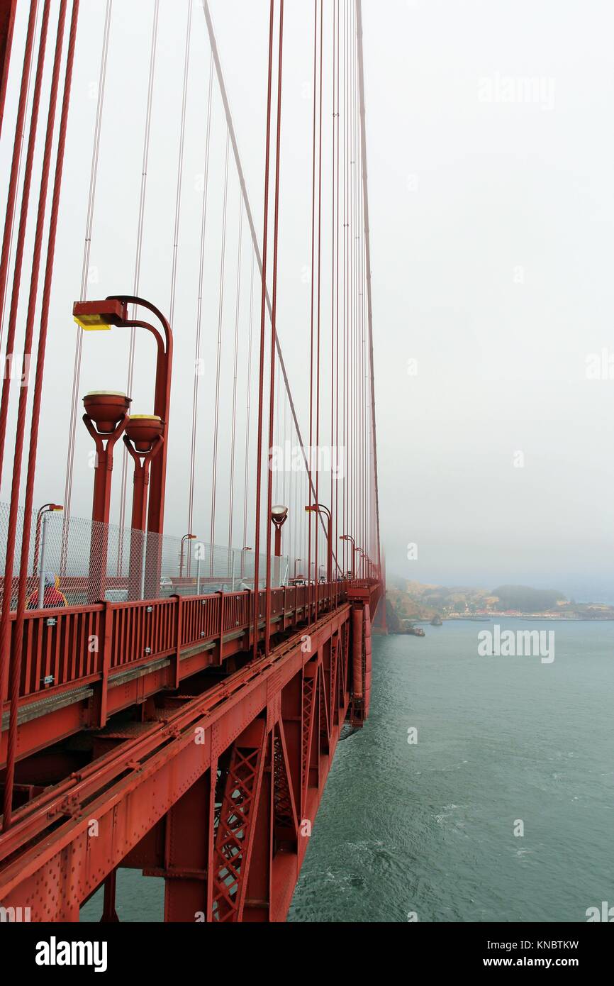 A view of the side of the Golden Gate Bridge, Marin County and the Pacific Ocean from a viewing area on the Golden Gate Bridge on a foggy, smog Stock Photo