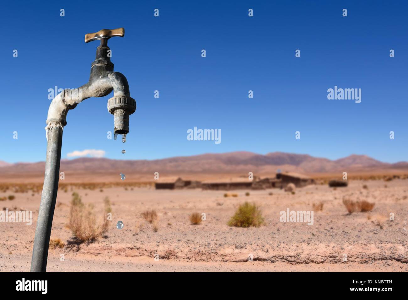 Drips faucet and dry environment in the background. Stock Photo