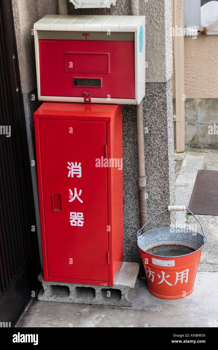 Kyoto, Japan, Traditional red fire bucket with water in front of the house as fire prevention in Kyoto. Stock Photo