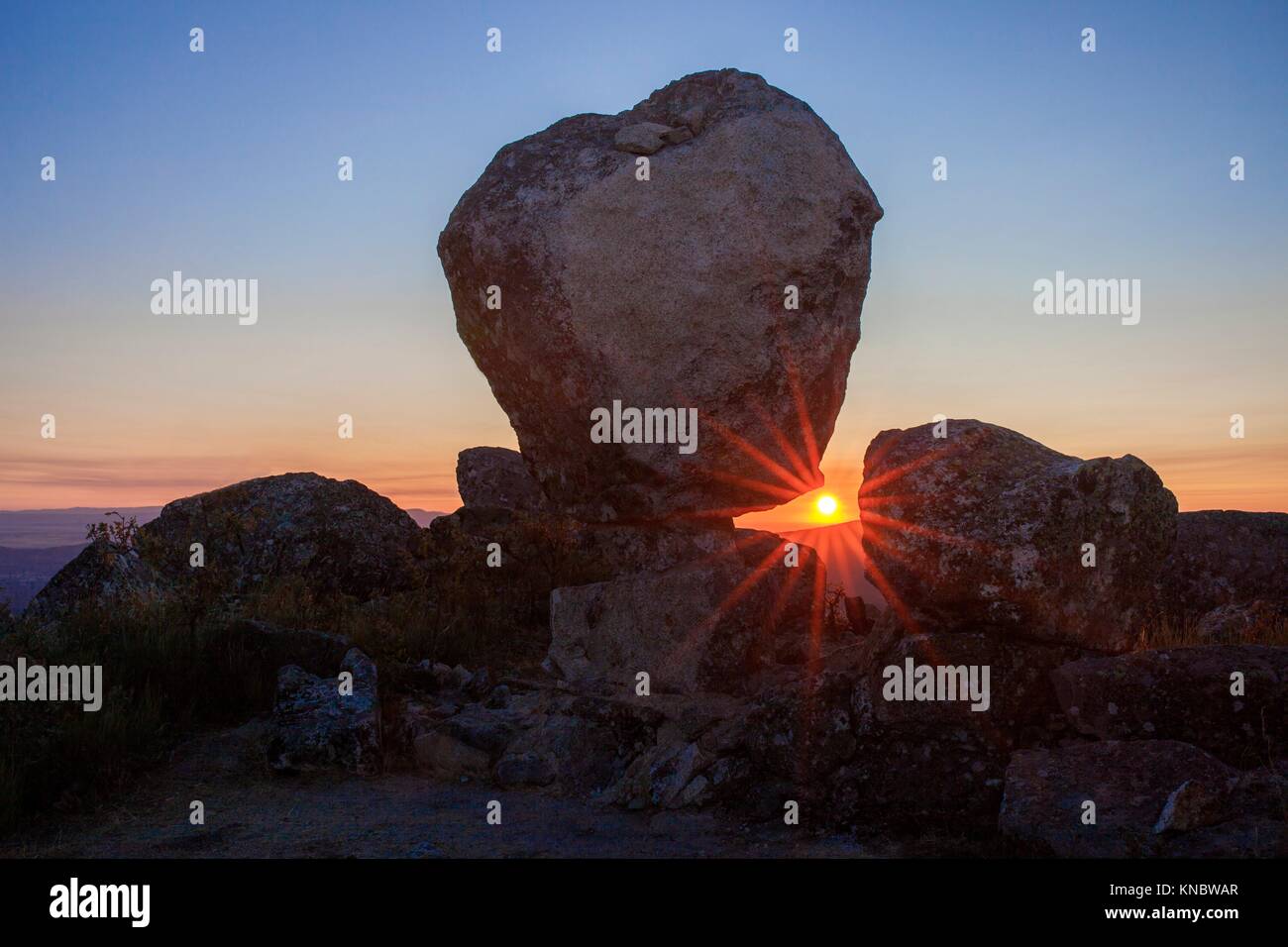 Sun rising between megalithic monument of Cancho Que Se Menea. In English shifting rock. Montanchez, Spain. Stock Photo