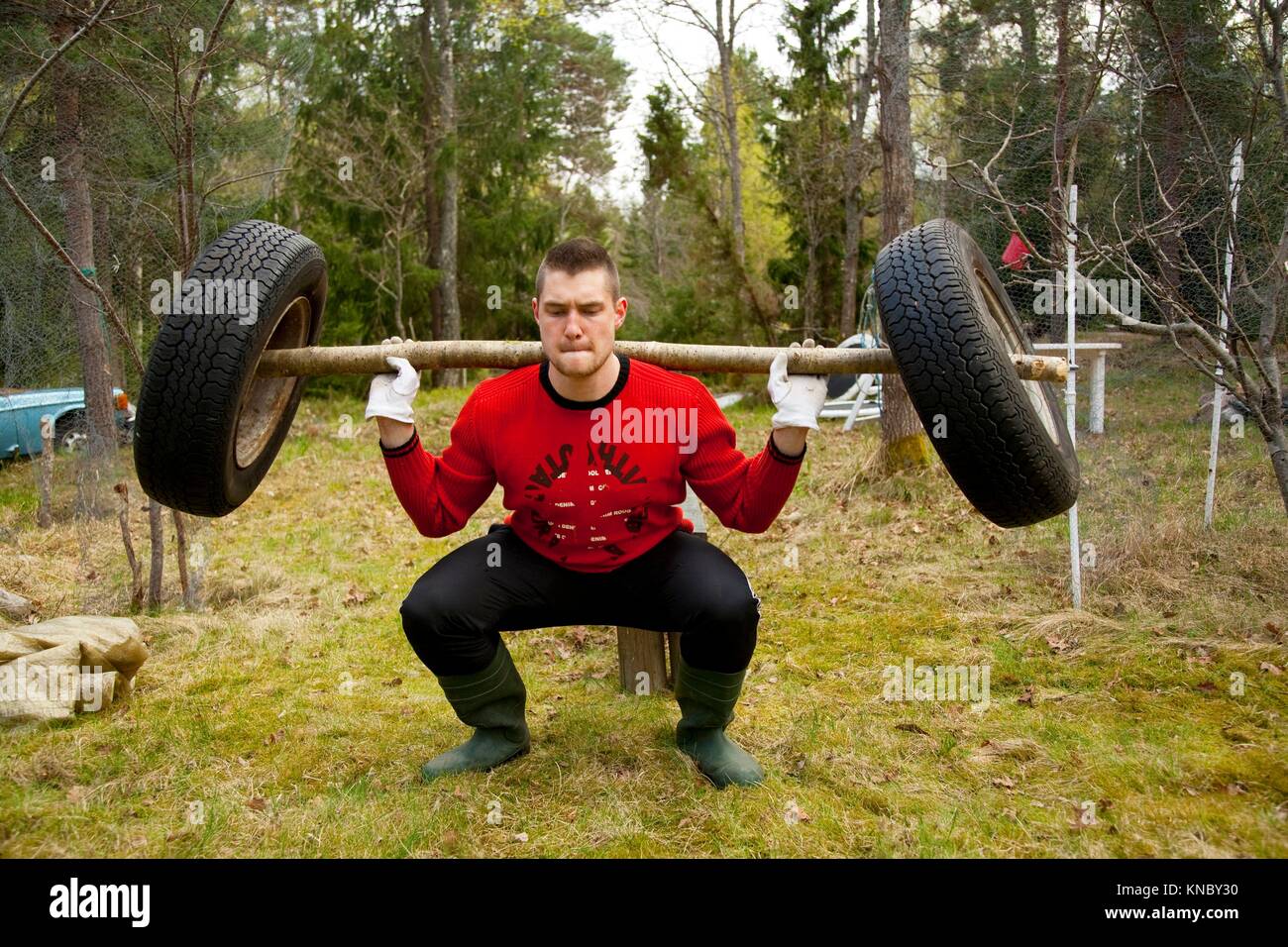 Man weightlifting in nature with homemade barbell swedish