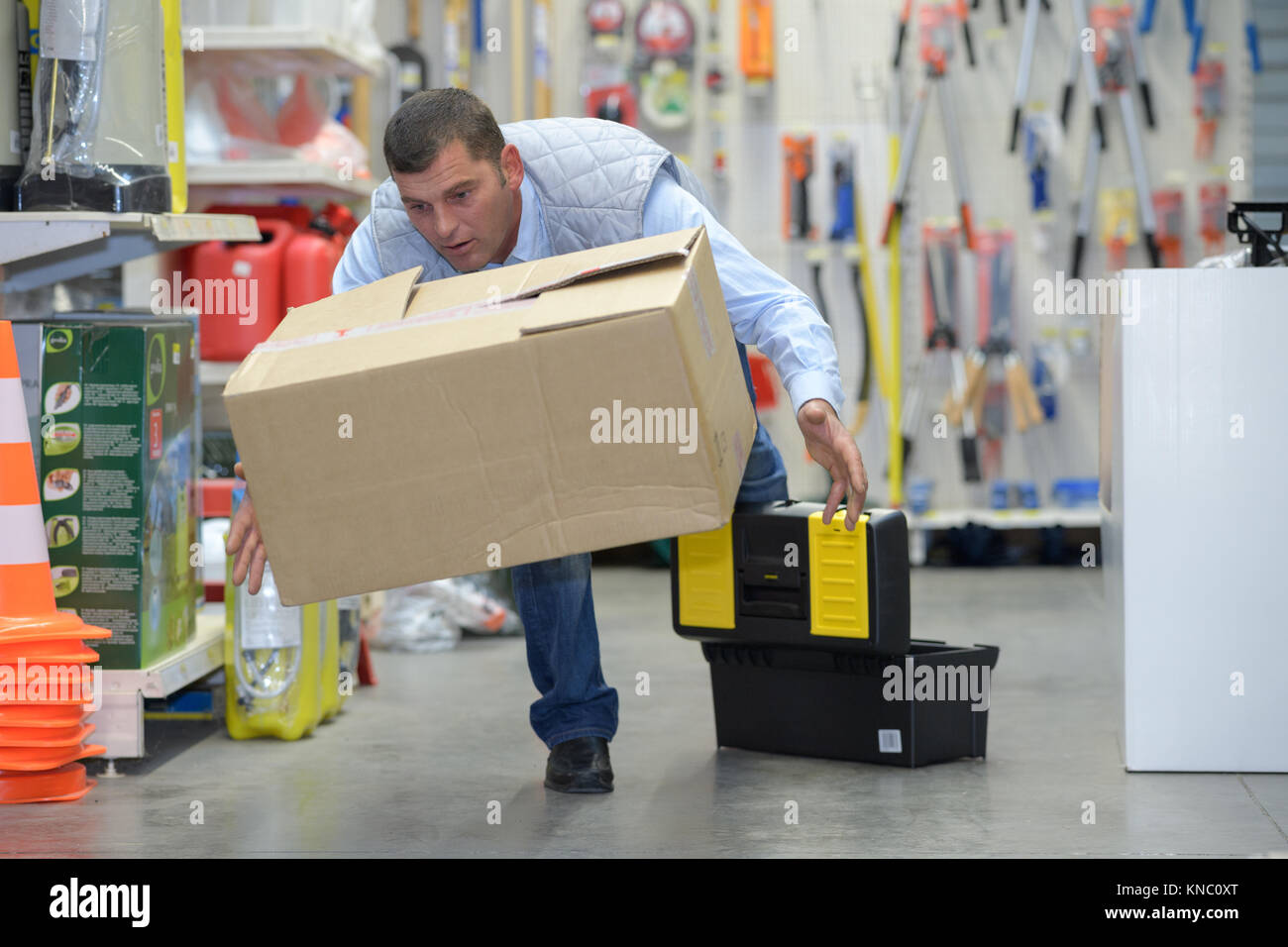 worker with backache while lifting box in the warehouse Stock Photo
