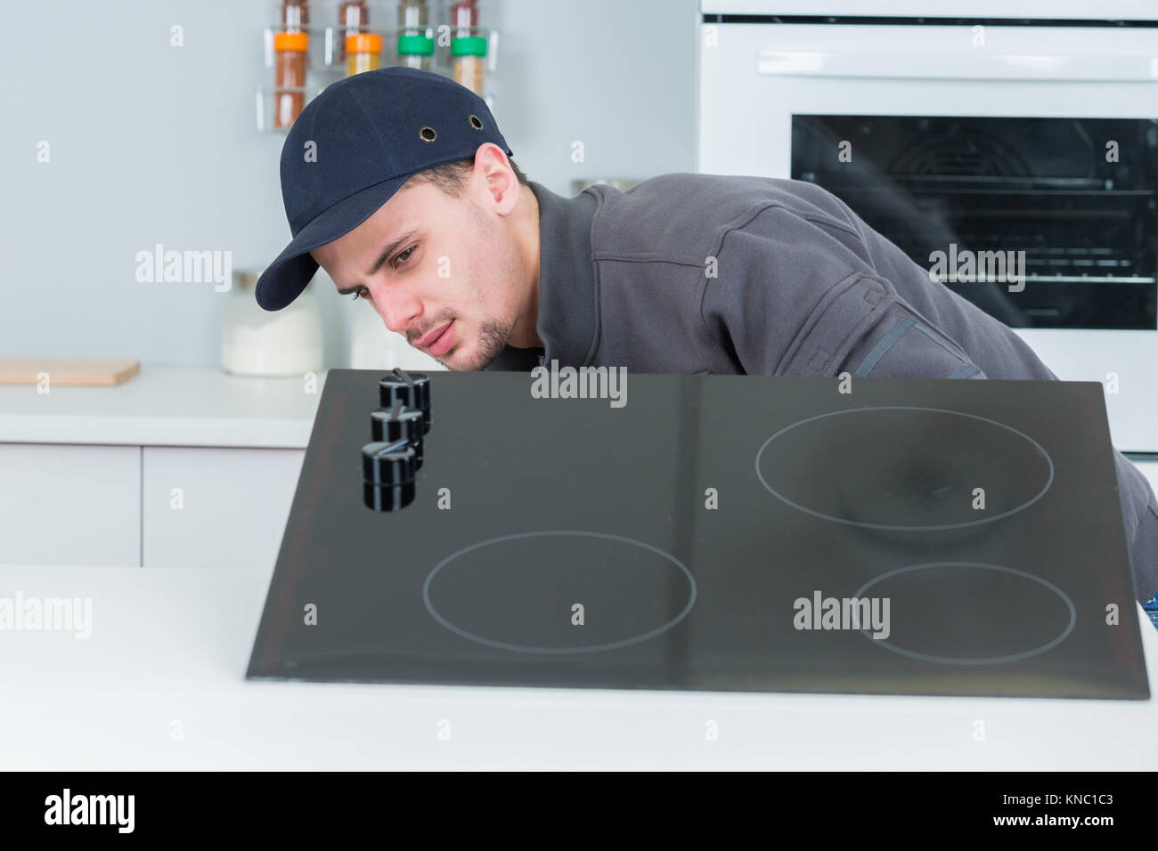 installing new induction hob in clients kitchen Stock Photo Alamy