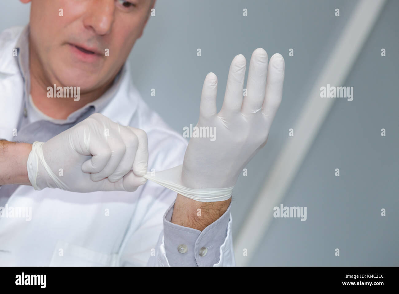 surgeon wearing gloves before surgery Stock Photo Alamy