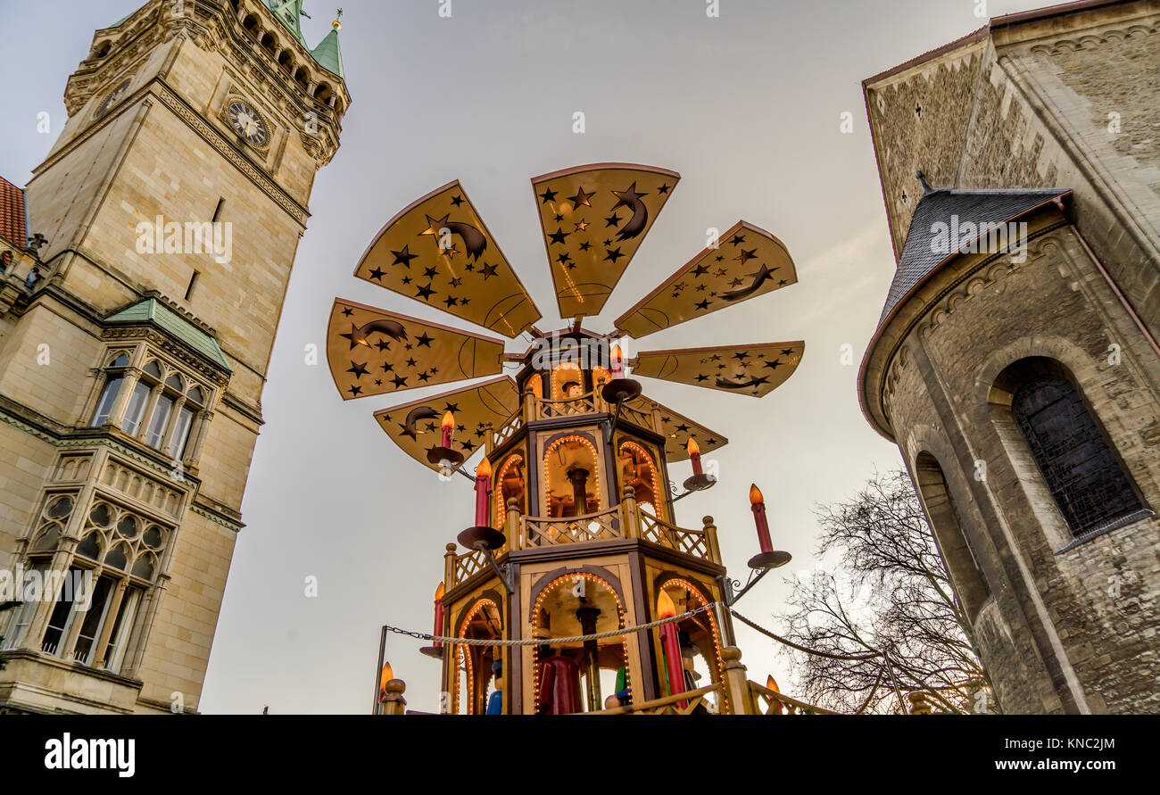 Huge Christmas pyramid at the Christmas market in Braunschweig with the town hall and the cathedral in the background Stock Photo