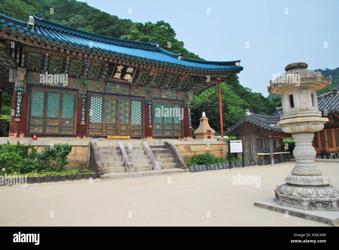 Korean-styled detailed architecture of the main building and stone lantern in the foreground. Symbol of buddhism, religio, faith, and peace. Stock Photo