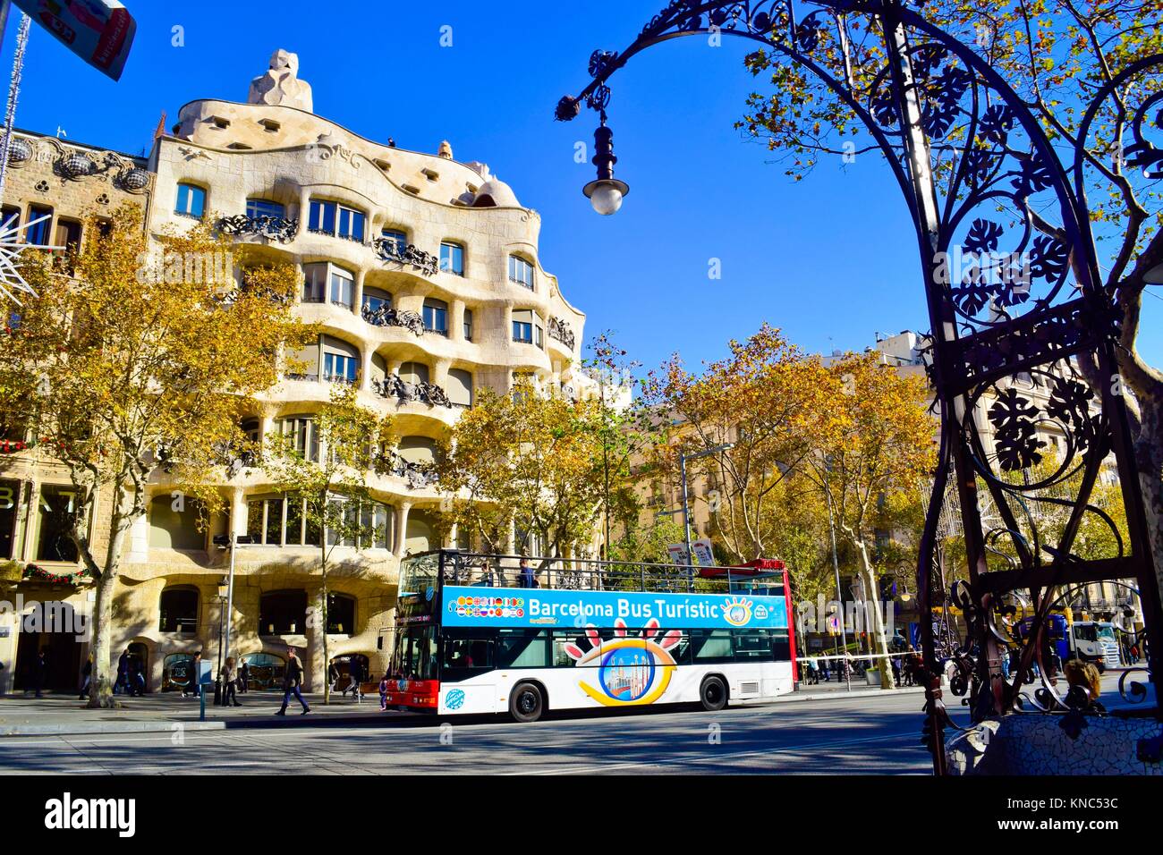 Barcelona Bus Turistic in front of Casa Milà, better known as La Pedrera. Designed by the Catalan architect Antoni Gaudí in the Eixample district. Stock Photo