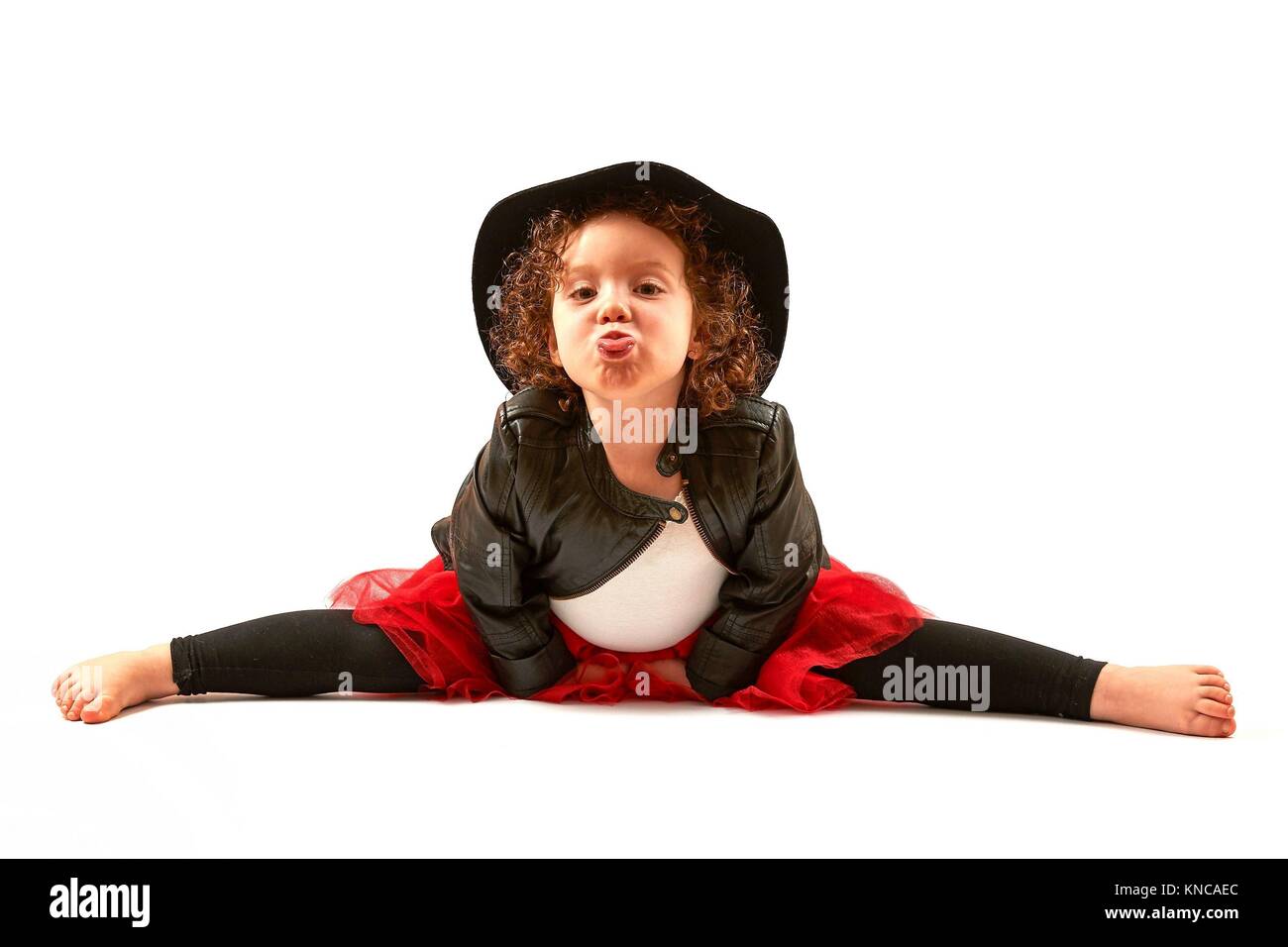 Little girl with black hat sitting and hamming. Stock Photo