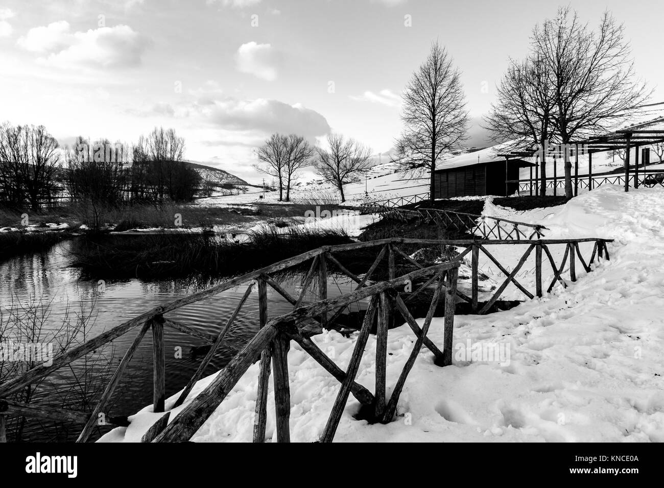 Colfiorito (Umbria) lake in winter, with snow all around, trees and a small wooden building Stock Photo