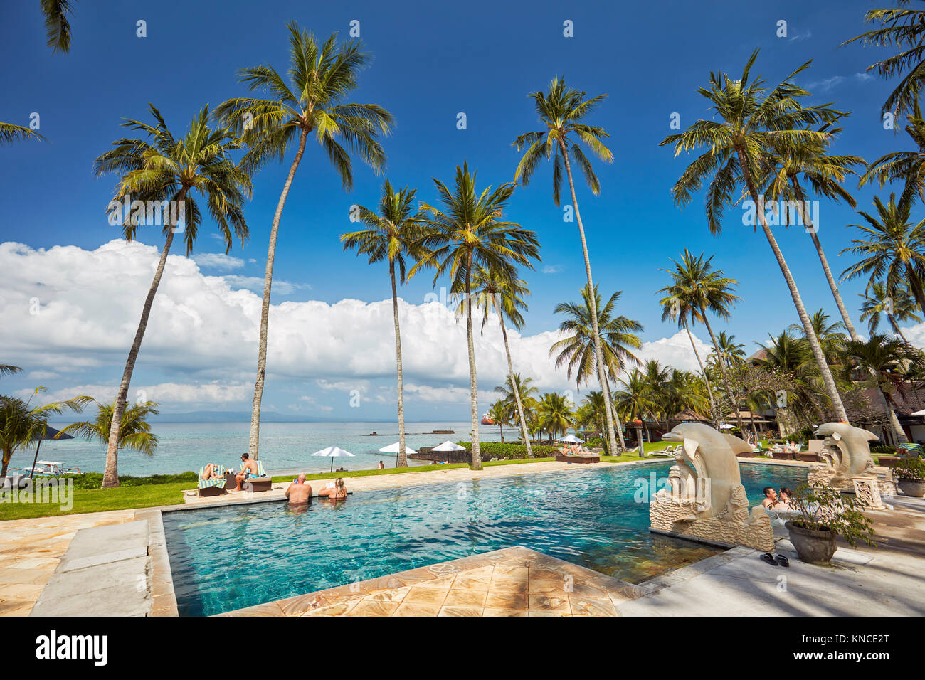 Swimming pool of Candi Beach Resort and Spa with a view towards Sengkidu Beach. Candidasa, Manggis subdistrict, Karangasem regency, Bali, Indonesia. Stock Photo