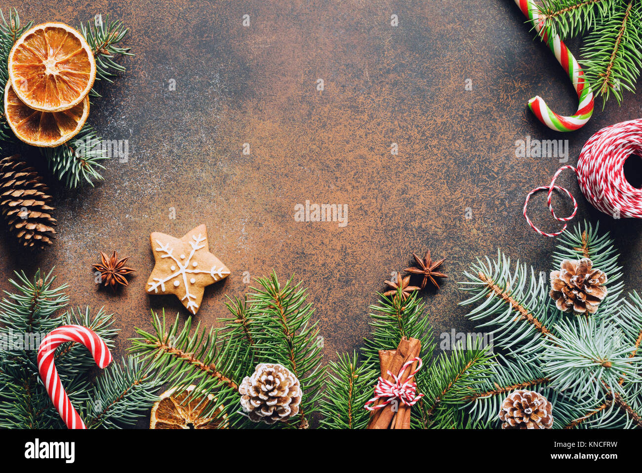 Traditional Christmas background with fir tree branch, candy cane, pine cones, dried fruit and gingerbread cookie. Copy space for text Stock Photo
