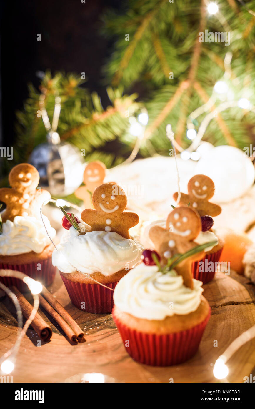 Gingerbread cupcakes, gingerbread cookies and Christmas lights. Closeup view, selective focus Stock Photo