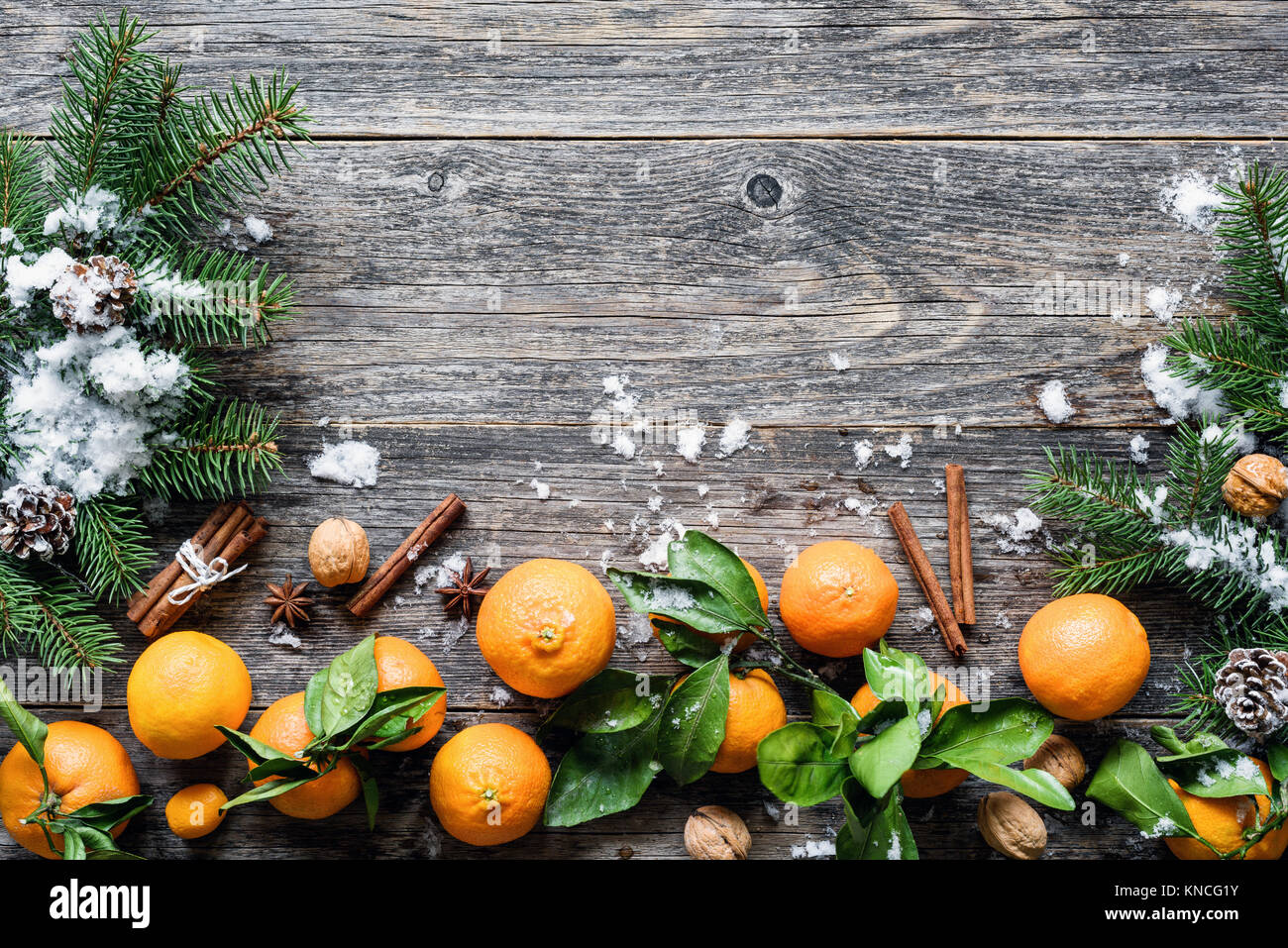 Tangerines, spices and fir tree on old wooden background. Traditional Christmas composition, winter wallpaper, greeting card template Stock Photo