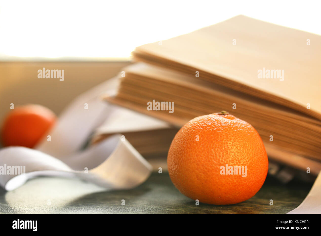 tangerines and vintage books on a marble table by the window Stock