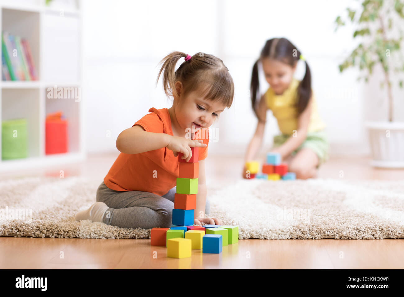 Kids playing block toys in playroom at nursery Stock Photo